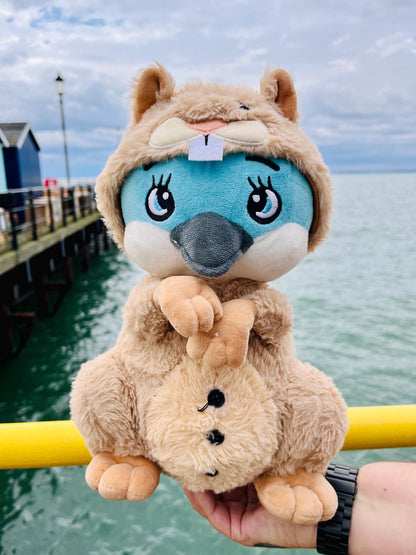 Life photo of CwaZyHog's Wally the disguise master the blue penguin with a squirrel onesie by CwaZyLeigh Creations in front of a pier